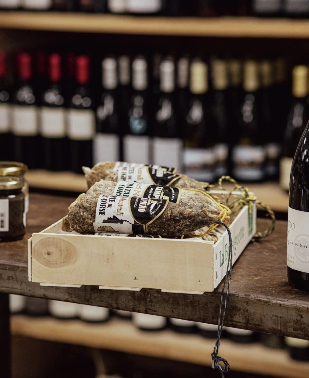 une image de trois saucissons dans une caisse en bois.